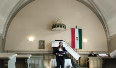 Egy hölgy szöveget olvas fel a szószék előtt állva a templomban.