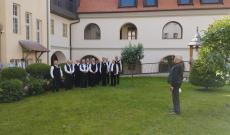Egy férfikar énekel egy templomkertben