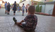 Utánpótlás Kisfiú nézi a körben táncoló, játszó nagyokat