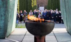 A temető örökmécsesén túl a megjelentek a koszorúzásra készülnek megemlékezés